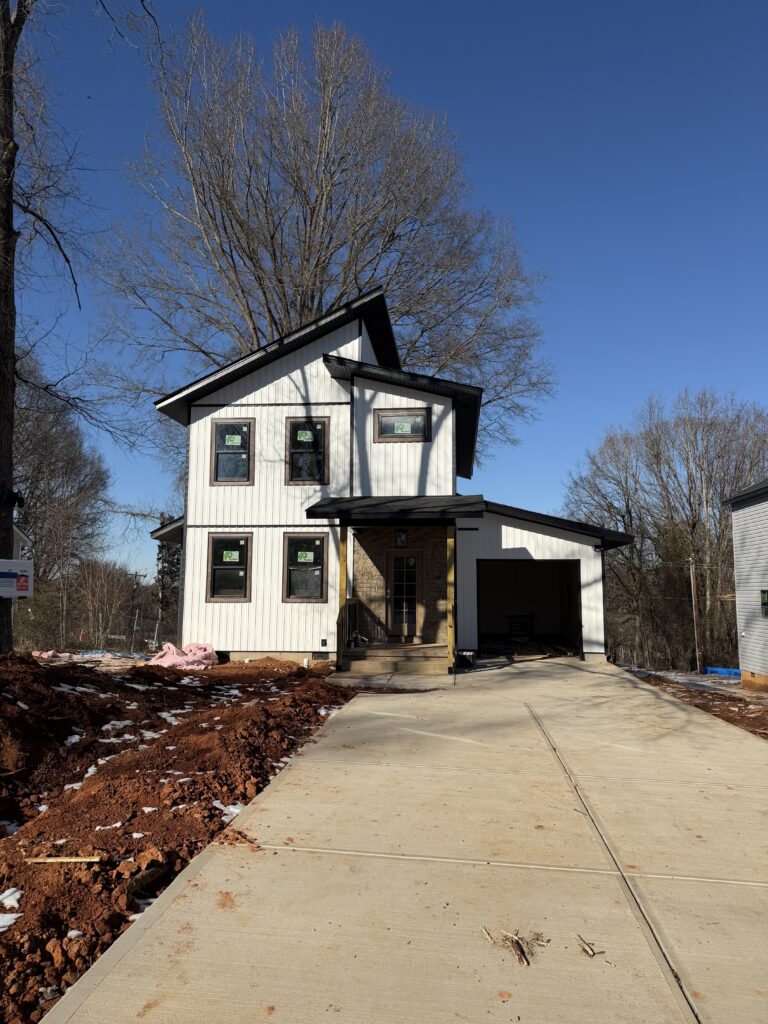 Two-story home with white siding nearing completion