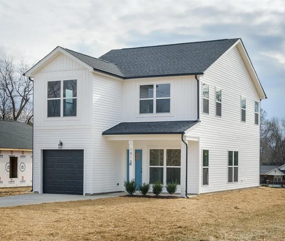 White two-story home with a dark garage door