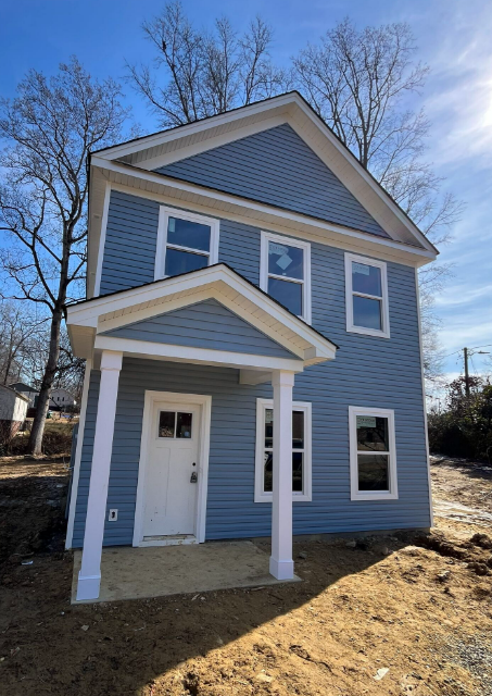 Blue two-story home with a covered front porch and white columns