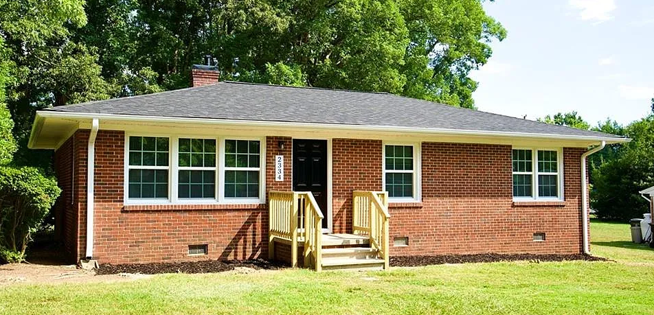 Brick ranch home with a new wooden front porch and steps