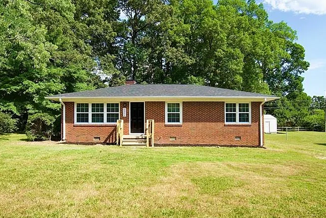 Single-story brick ranch home with a green front lawn